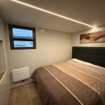 Großes Schlafzimmer mit Boxspringbett und Smart TV