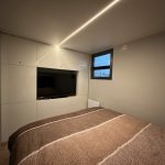 Großes Schlafzimmer mit Boxspringbett und Smart TV