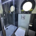 Badezimmer mit Dusche und Bullauge